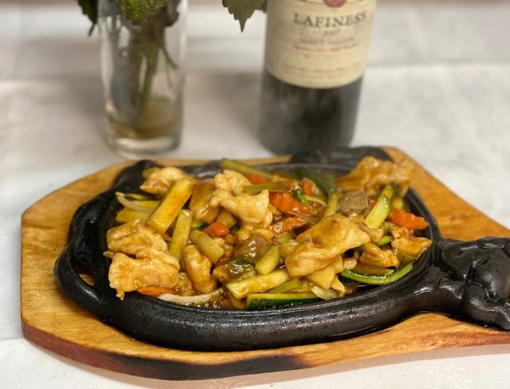 Mongolian-style chicken breast on a sizzling plate